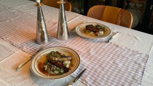 two plates of risotto with Lamb and candle sticks